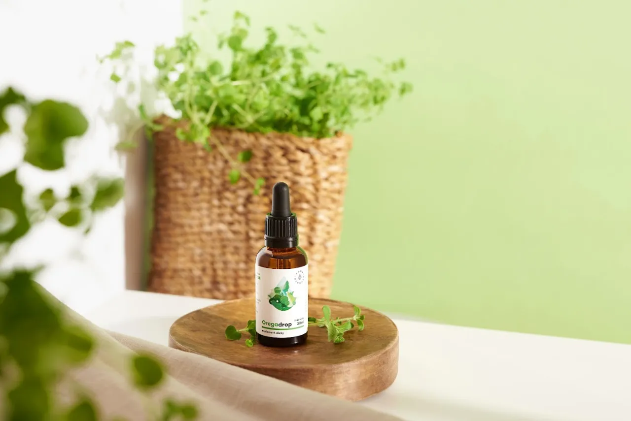 Olejek oregano na odporność i trawienie. Naturalny suplement diety w kroplach, otoczony świeżymi ziołami.