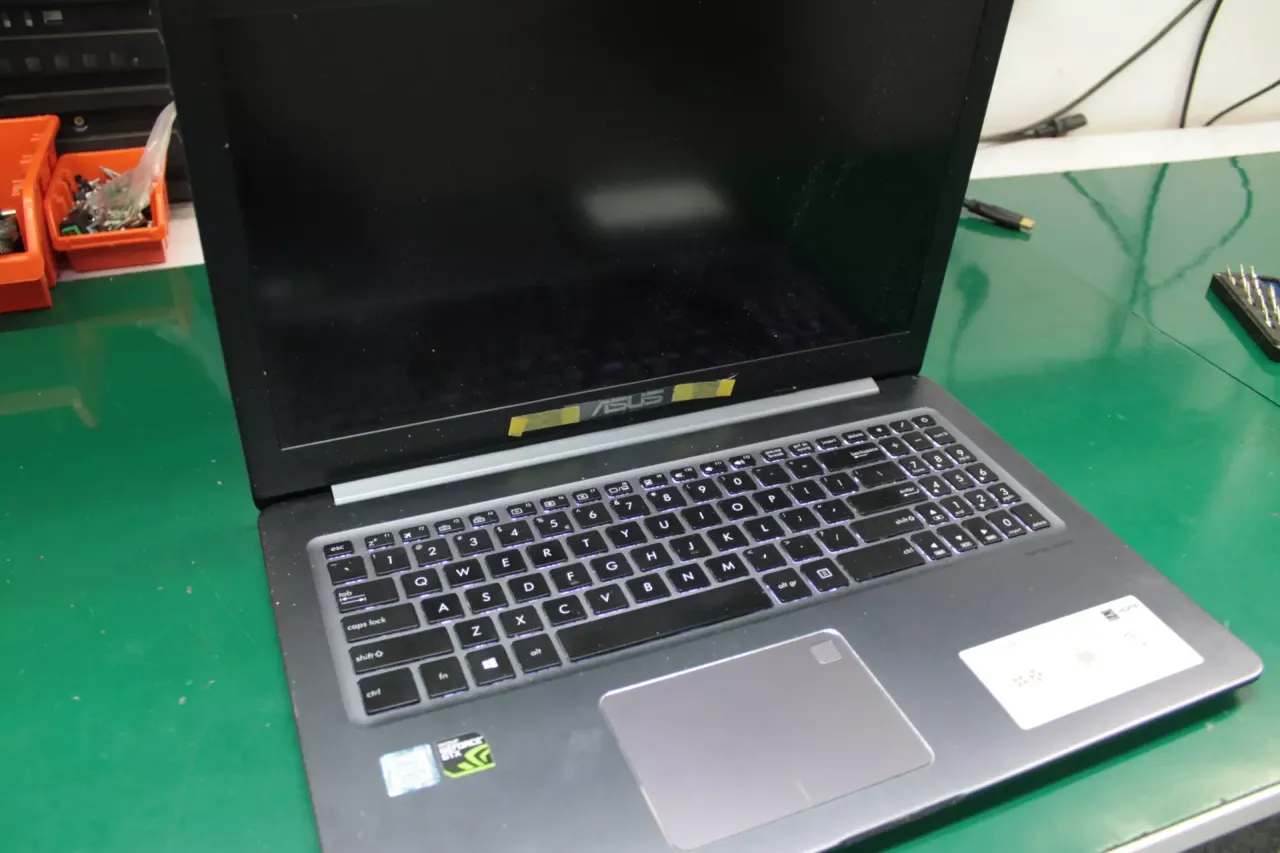 osoba naprawiająca laptopa czarny ekran