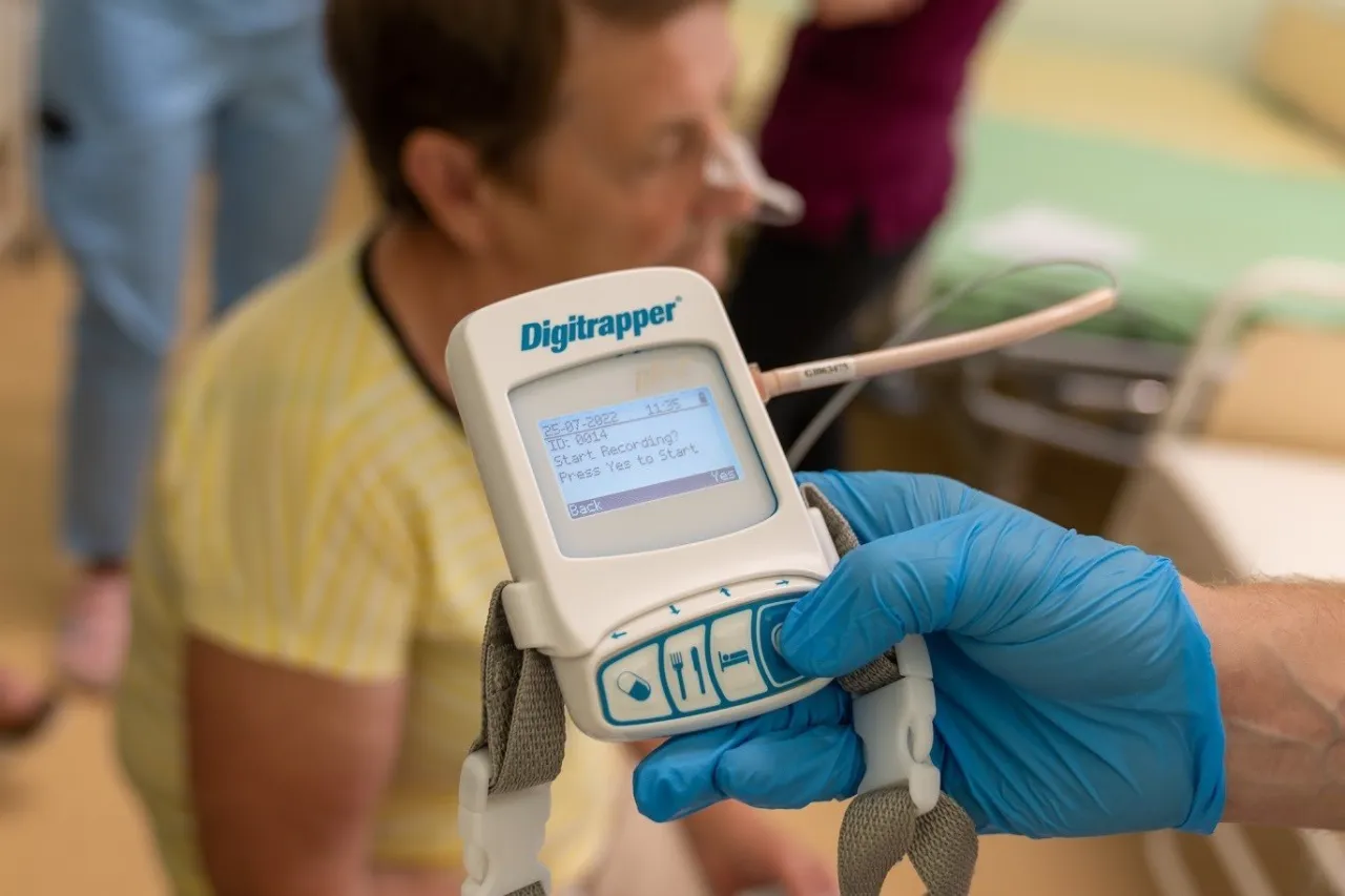 Pacjent z sondą nosową, przygotowywany do badania na refluks. Urządzenie Digitrapper rejestruje dane.