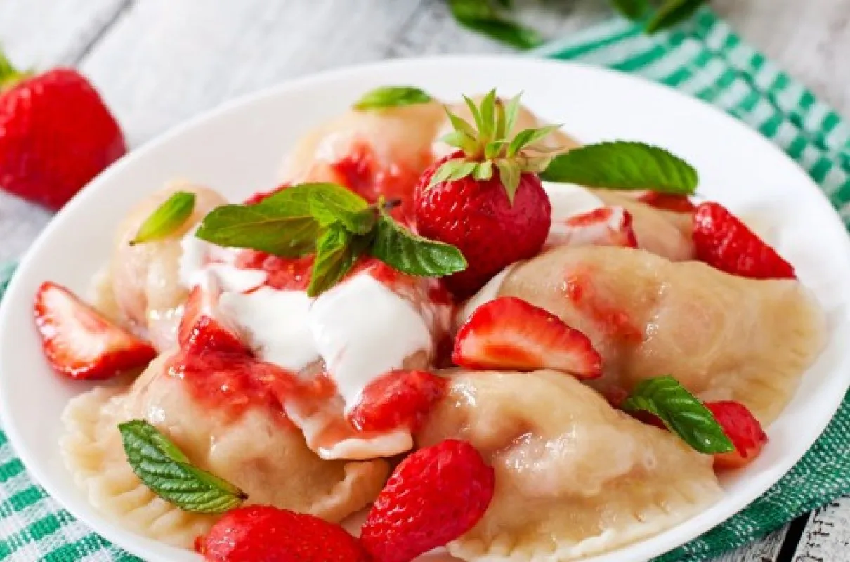 Pyszne pierogi z truskawkami i bitą śmietaną, idealne na deser. Dowiedz się, jak odmrozić pierogi, by smakowały jak świeże!
