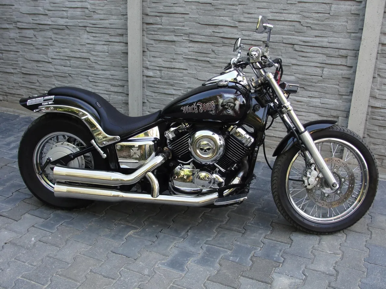 Czarny motocykl Yamaha Drag Star 650 z ozdobami czaszek. Pojemność baku jest wystarczająca na długie podr&oacute;że.