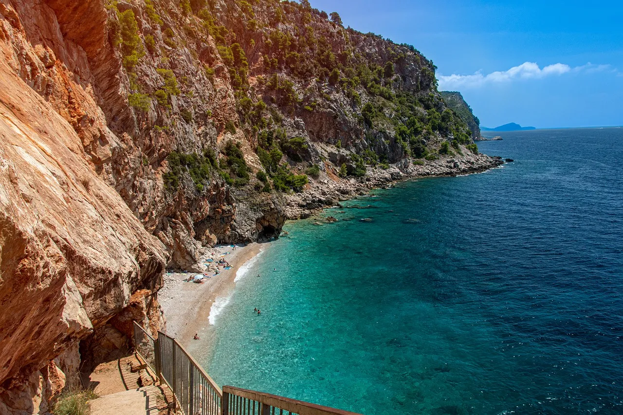 Malownicza zatoka z kamienistą plażą i turkusową wodą. Idealne miejsce, by sprawdzić, co warto zwiedzić w okolicach Trogiru.