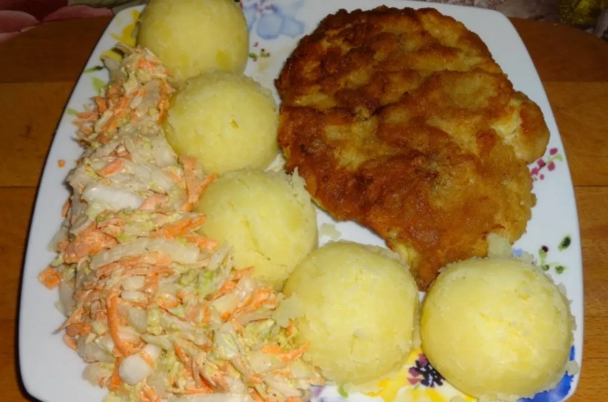 Idealna jaka sałatka do schabowego? Ta z kapusty i marchewki, podana z ziemniakami i panierowanym kotletem.