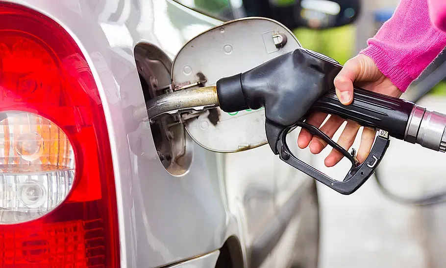 Automechaniker pumpt Kraftstoff aus einem Tank an einer Hebeb&uuml;hne