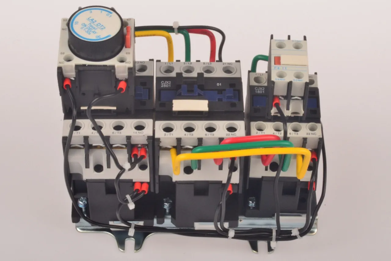 Złożona instalacja w gwiazdę z przekaźnikiem czasowym LA2 DT2, stykami pomocniczymi i przewodami w kolorach ż&oacute;łtym, zielonym i czerwonym.