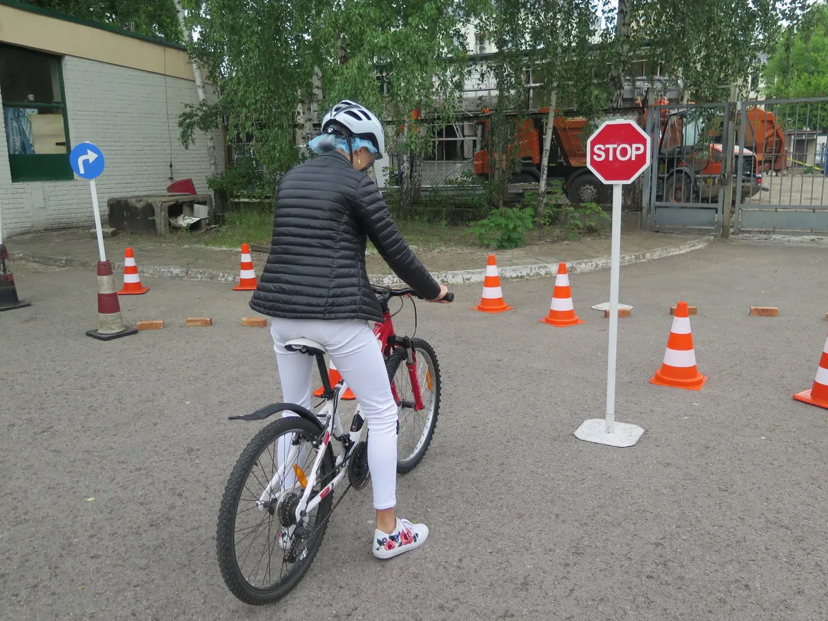 Dziecko może jeździć na rowerze bez karty rowerowej, ale musi przestrzegać zasad ruchu drogowego, co widać na tym torze przeszk&oacute;d z pachołkami i znakiem STOP.