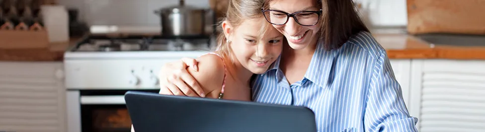 dziecko uczy się w domu przy komputerze z rodzicem