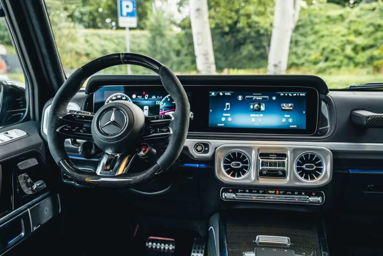 Wnętrze Mercedes G Klasa AMG z nowoczesnym kokpitem i ekranami.