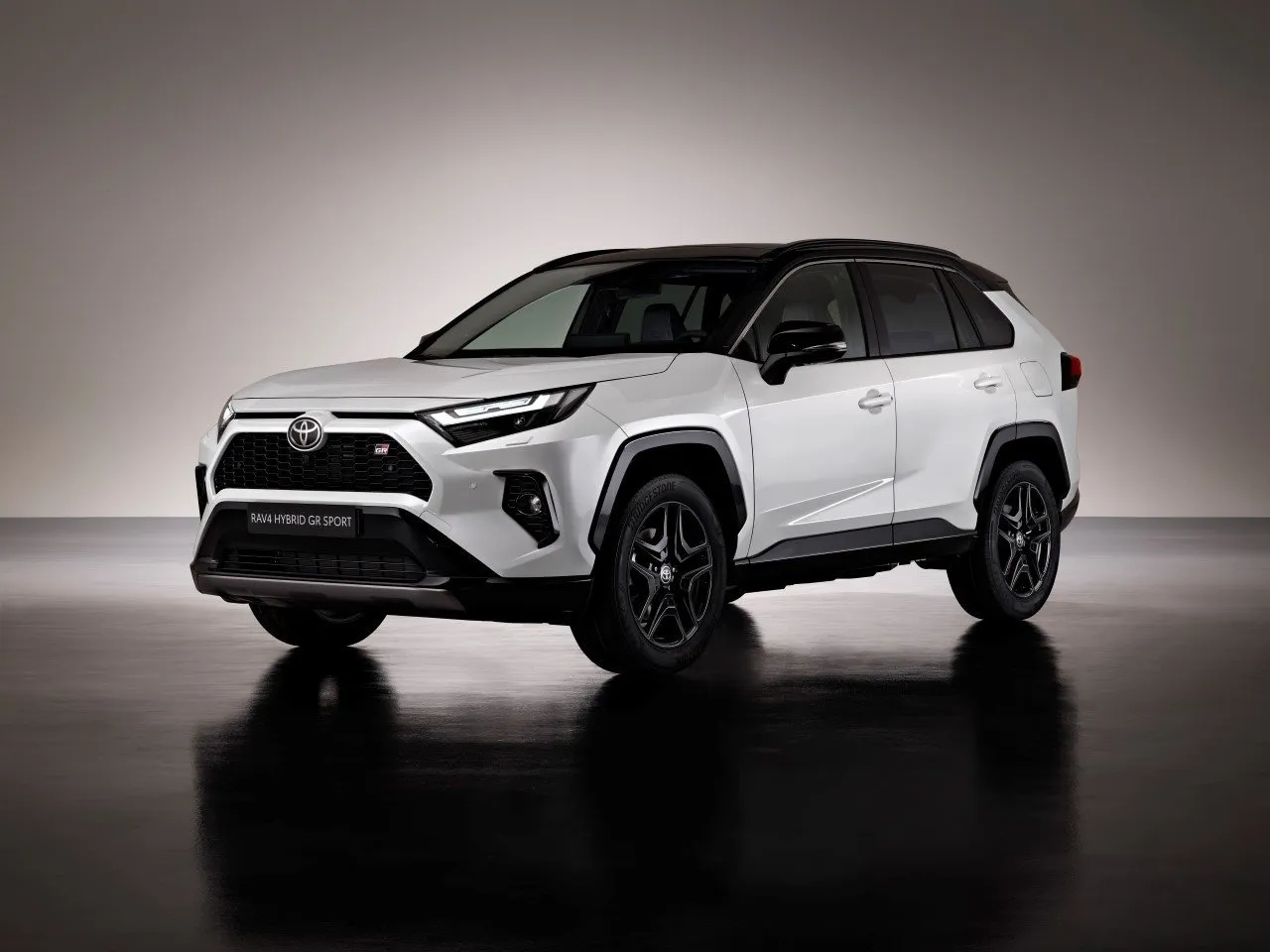 Biała Toyota RAV4 Hybrid GR Sport z czarnym dachem. Zastanawiasz się, ile kosztuje Toyota RAV4 w tej wersji?