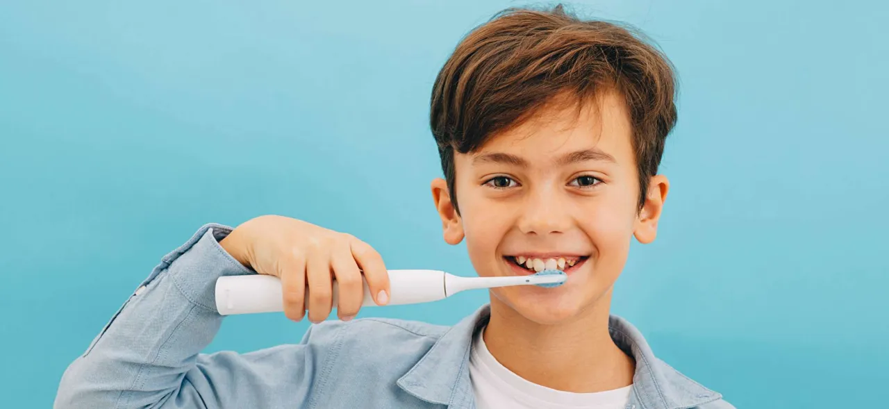 dziecko myjące zęby szczoteczką elektryczną z timerem