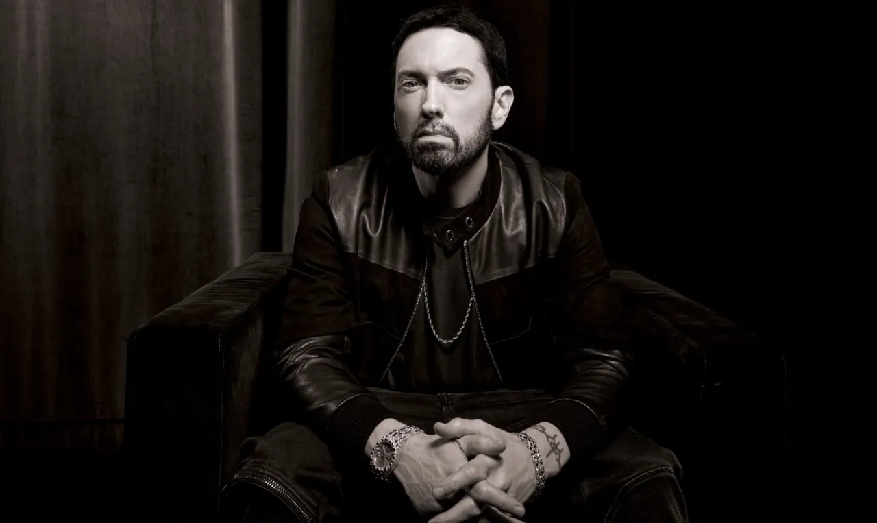 Eminem siedzi w fotelu, ubrany w sk&oacute;rzaną kurtkę. Wszelkie plotki o tym, czy Eminem żyje, są bezpodstawne.