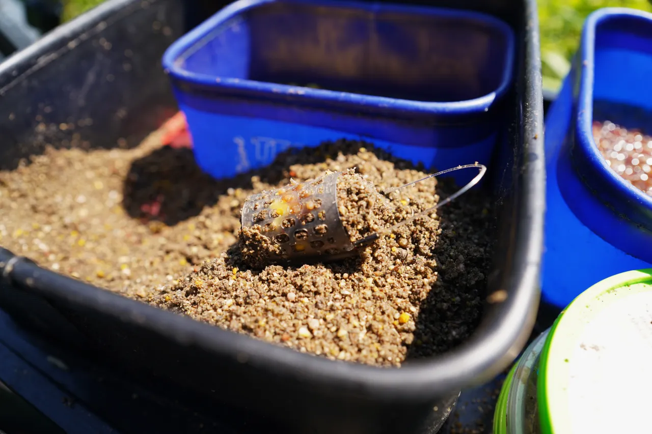Szykujesz się na połów? Widać tu najlepszą zanętę do metody, gotową do użycia w koszyczku.