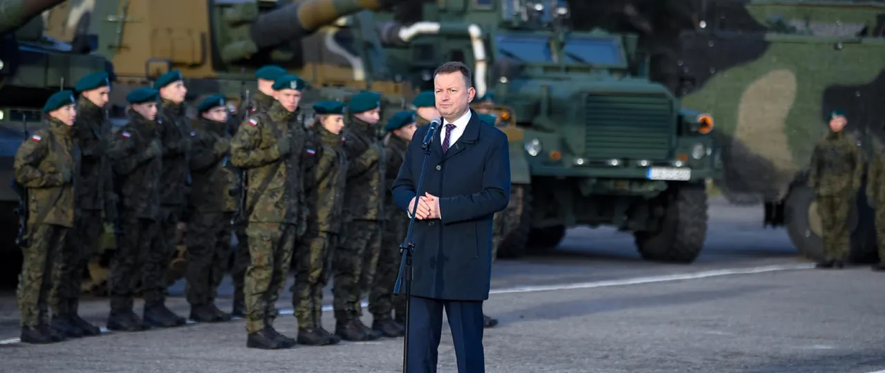 Mężczyzna w płaszczu przemawia do żołnierzy w mundurach i beretach, stojących przed czołgami. To może być początek szkolenia, jak zostać kierowcą czołgu.