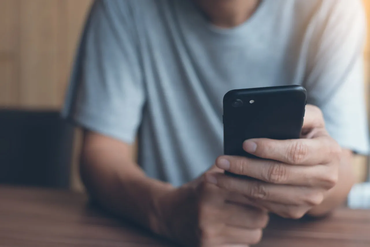 osoba trzymająca telefon, na ekranie komunikat o błędzie aktualizacji