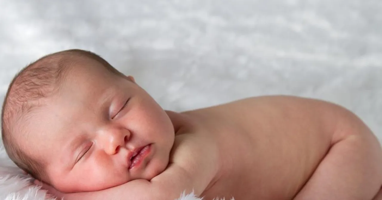 Śpiące niemowlę, które przechodzi skok rozwojowy. Delikatne rysy twarzy, spokojny sen.