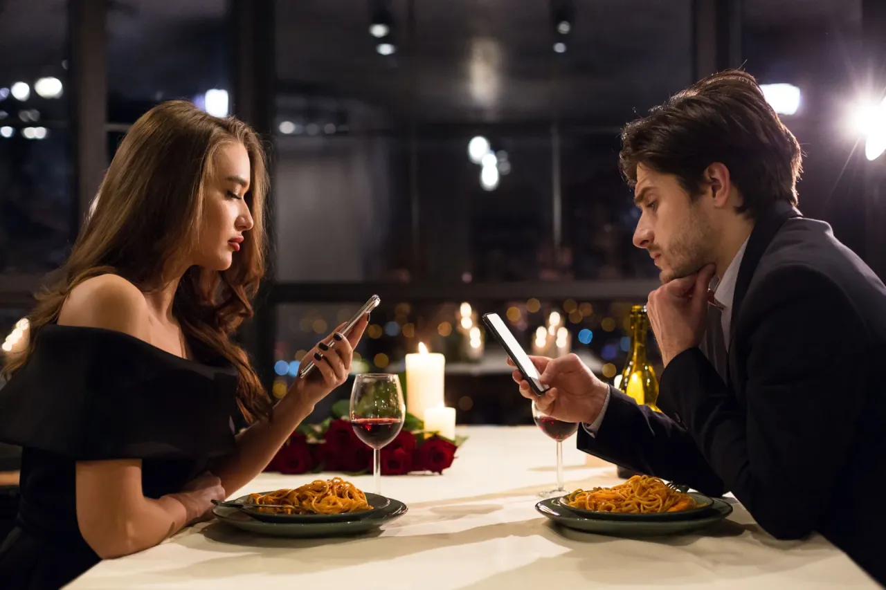 Para na randce z telefonem na stole, ignorowanie partnera