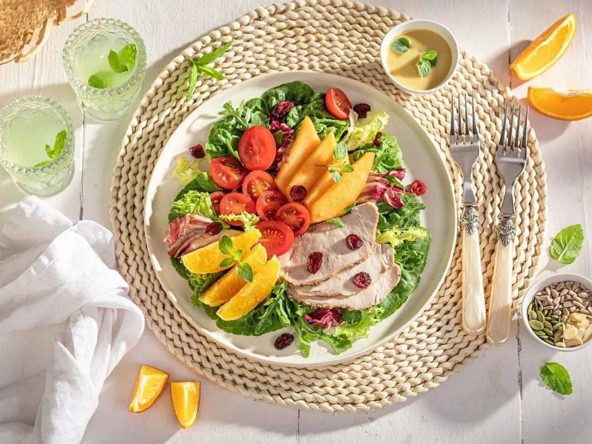 Kolacja pełna smaku i zdrowia: sałatka z pieczonym indykiem, pomidorkami, pomarańczą i melonem. Idealne co dietetycznego na kolację.