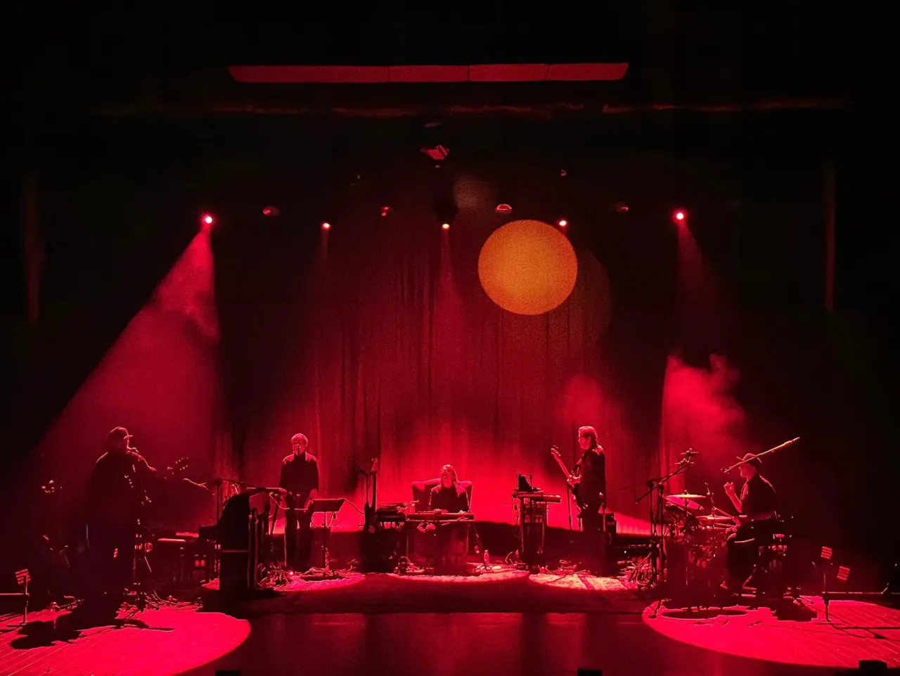 Zesp&oacute;ł gra na scenie w czerwonym świetle. Zastanawiasz się, ile trwa koncert korteza?