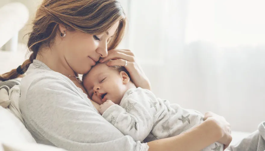rodzic przytulający niemowlę z czułością
