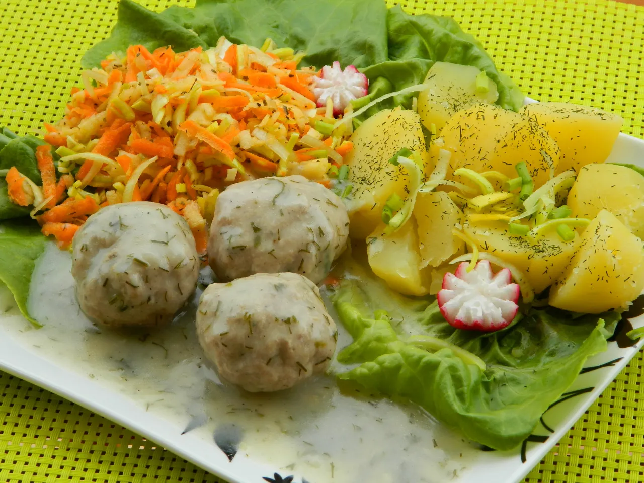 Pulpety w sosie koperkowym z ziemniakami i sur&oacute;wką z marchewki i kapusty. Idealne danie, by pokazać, z czym podawać pulpety w sosie koperkowym.