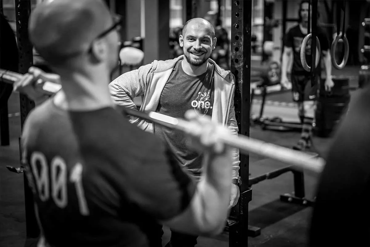 Osoba początkująca trenująca CrossFit pod okiem trenera