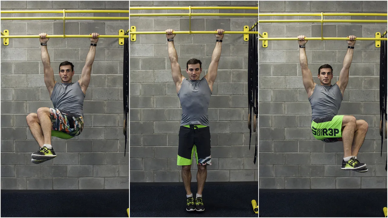 Mężczyzna wykonuje ćwiczenia na brzuch na siłowni, podciągając kolana do klatki piersiowej wisząc na drążku.