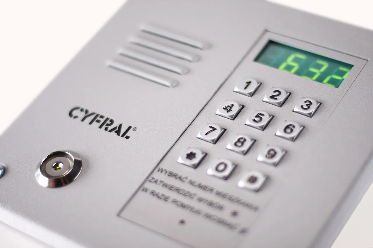 gość dzwoniący na domofon przy szlabanie