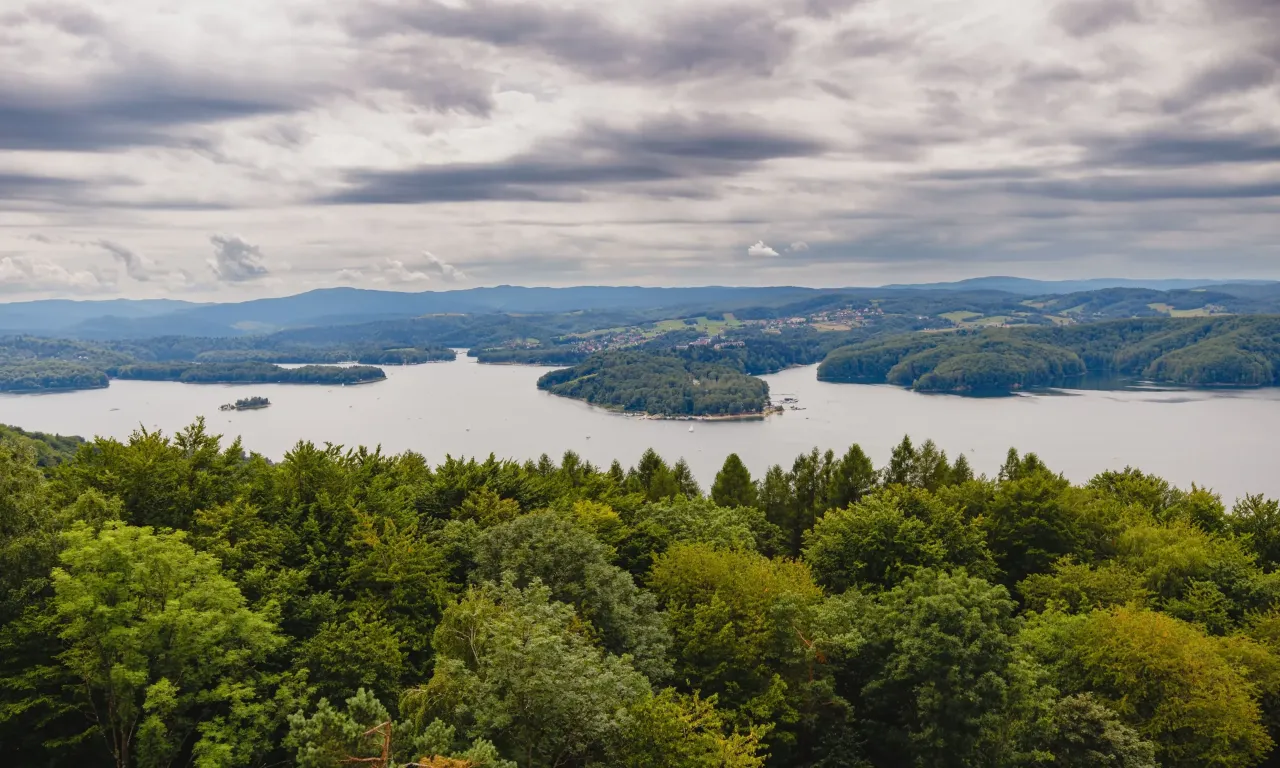 Zielone wzg&oacute;rza nad Soliną, gdzie wiatr szumi w drzewach, a jezioro odbija chmury.
