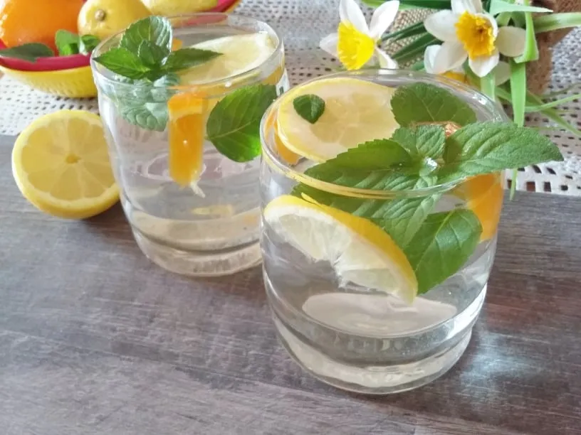 woda z cytryną i miętą w szklance, butelka z wodą z owocami