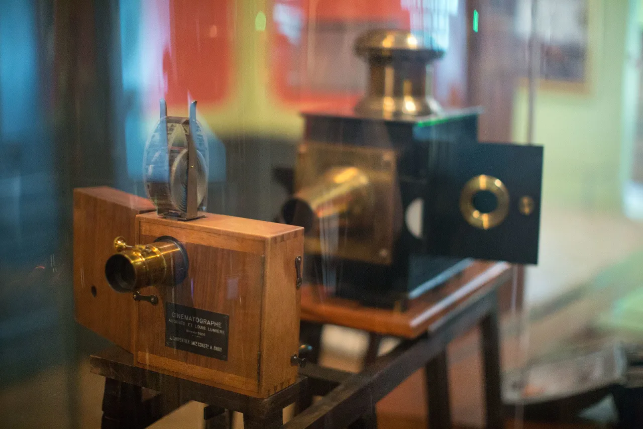 Drewniany kinematograf braci Lumière, urządzenie, które zapoczątkowało erę kina, z charakterystycznym obiektywem i mechanizmem.