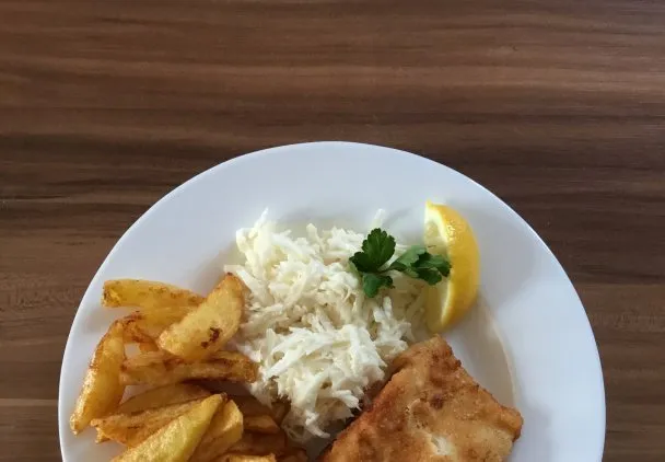 ryba z frytkami i sur&oacute;wką na talerzu