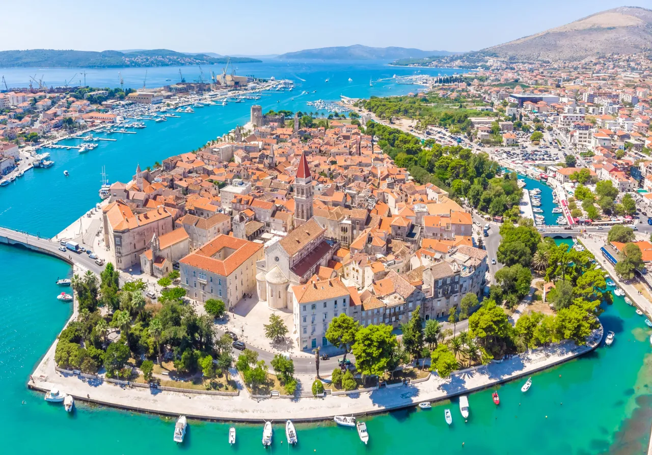 Widok na zabytkowe miasto Trogir i jego port. Idealne miejsce, by odkryć, co warto zwiedzić w okolicach Trogiru, od star&oacute;wki po pobliskie wyspy.