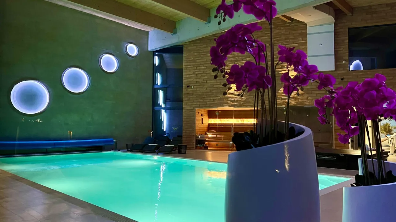 Relaks w nowoczesnym spa na Śląsku: basen, sauna i fioletowe storczyki tworzą atmosferę luksusu.