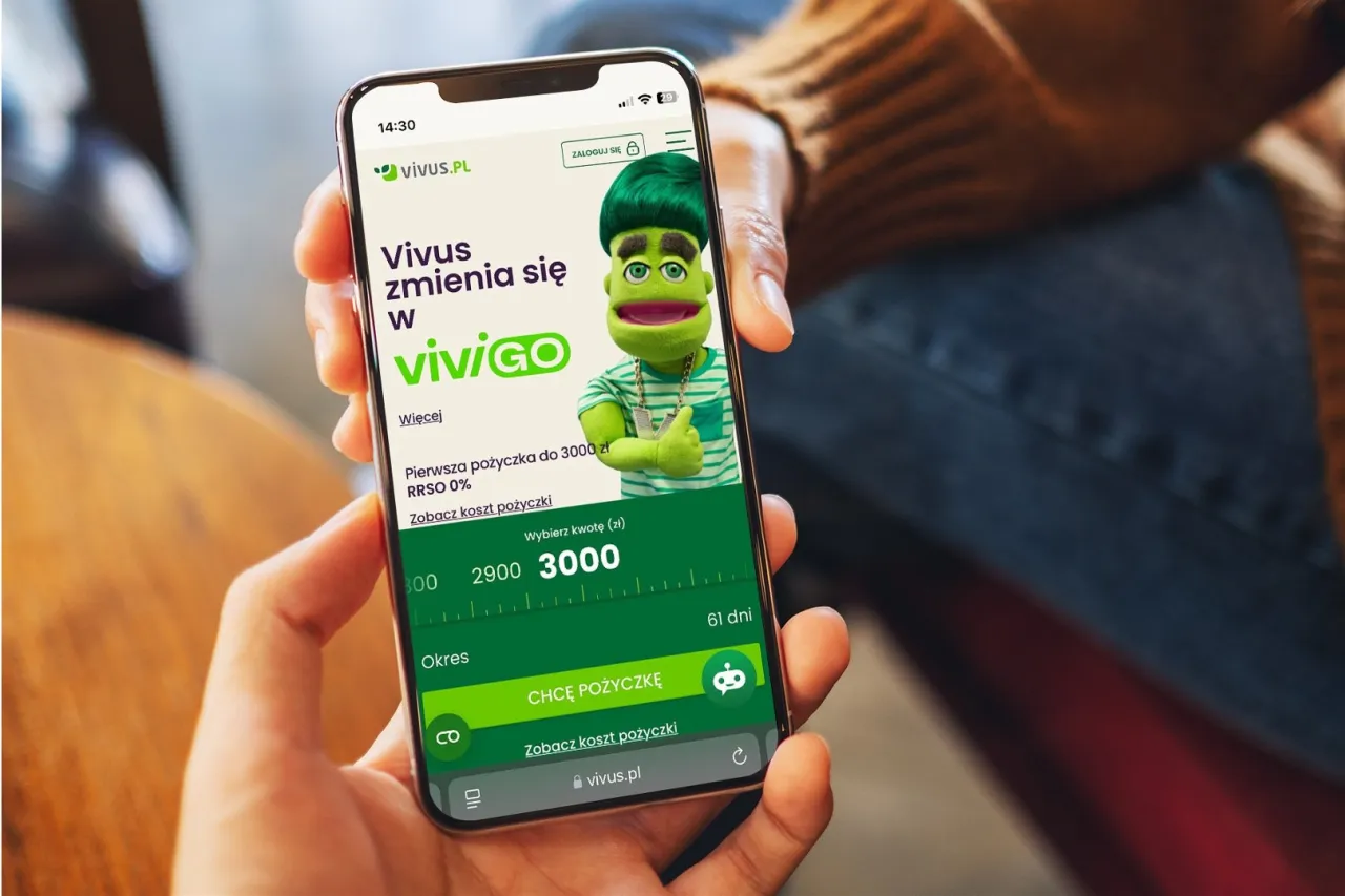 Na ekranie telefonu Vivus.pl widać zieloną postać, kt&oacute;ra zachęca do wzięcia pierwszej pożyczki do 3000 zł RRSO 0%. Czy Vivus jest bezpieczny? Aplikacja oferuje szybkie pożyczki.