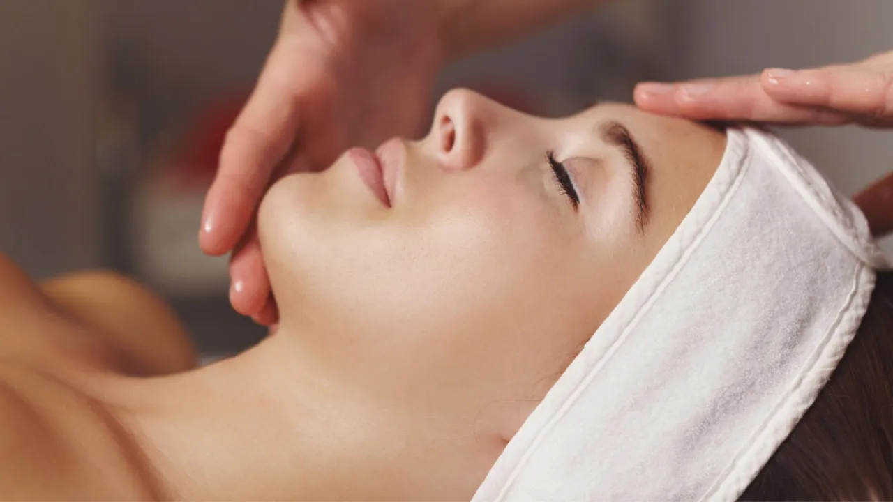 Delikatny dotyk dłoni na twarzy podczas zabiegu. Idealny moment, by zastanowić się, co uzywac do peelingu kawitacyjnego dla najlepszych efektów.