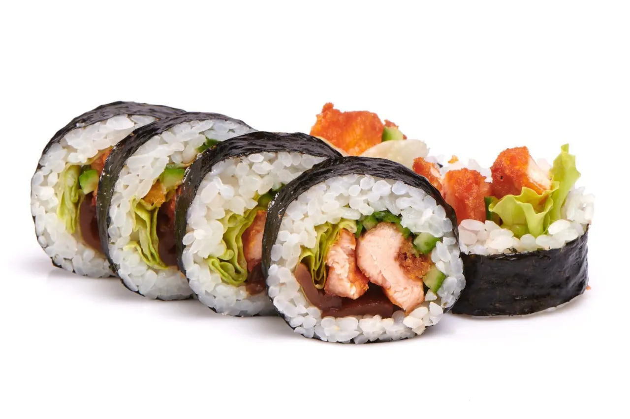 Futomaki z pieczonym łososiem, chrupiącym kurczakiem i świeżymi warzywami. Pyszne rolki sushi na białym tle.