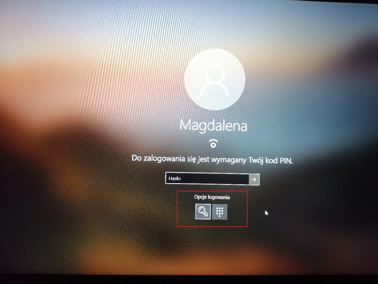 Ekran logowania Windows z opcjami logowania, w tym kluczem i klawiaturą numeryczną, sugerującymi możliwość użycia Windows Hello.