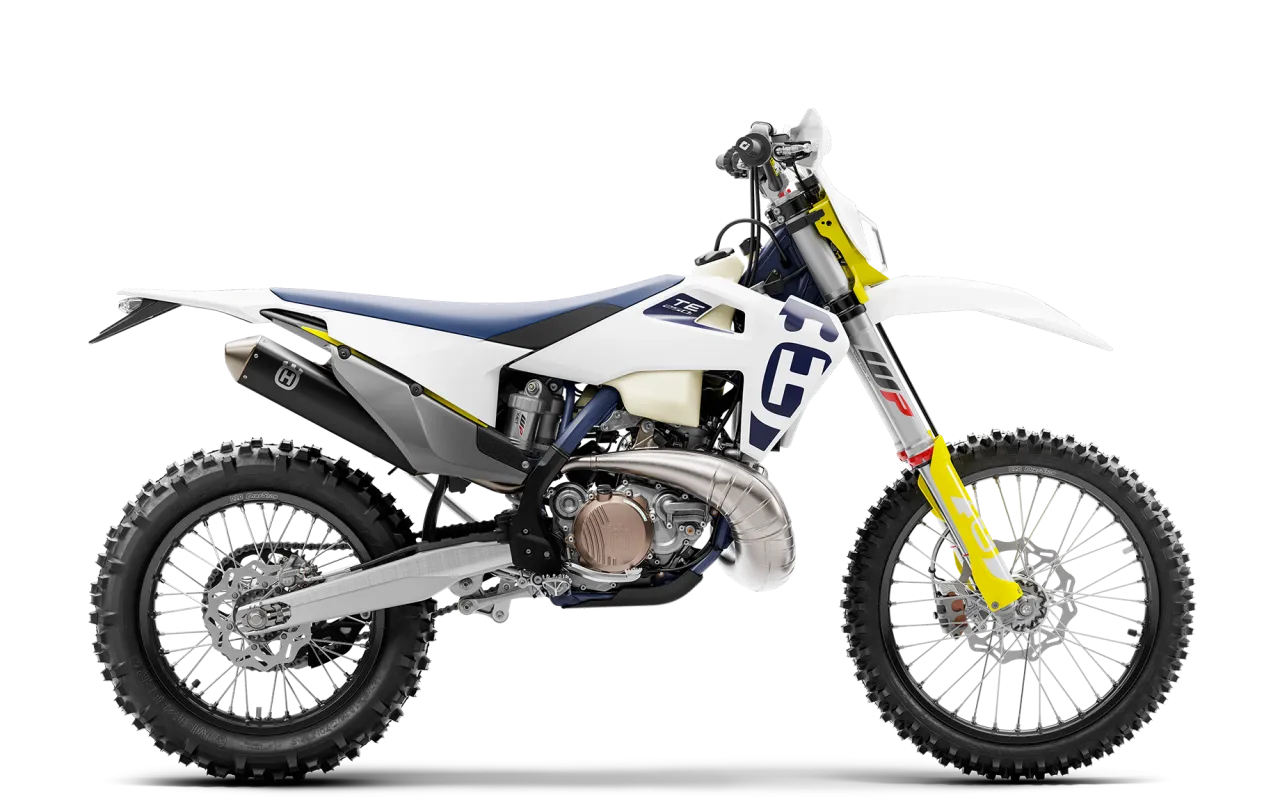 Biały motocykl Husqvarna 250 2t z niebieskim siedzeniem i żółtymi akcentami, gotowy na terenowe wyzwania.
