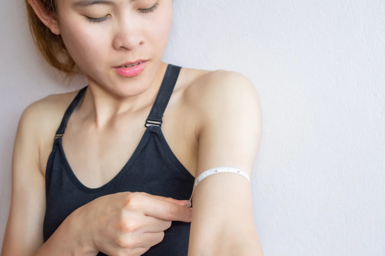 Osoba mierząca obwód talii z uśmiechem