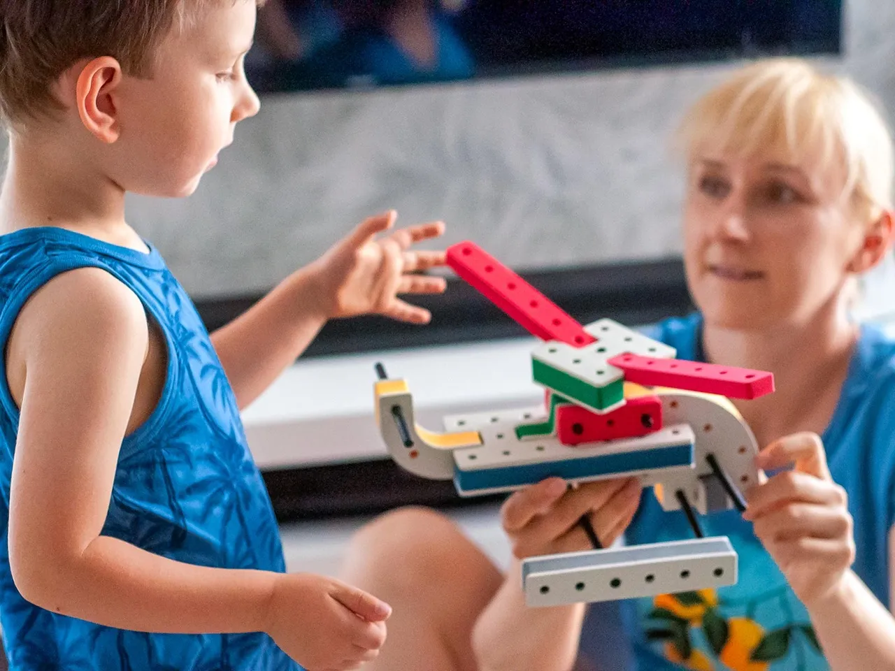 Ręce rodzica i dziecka wybierające kulko-klocki w sklepie