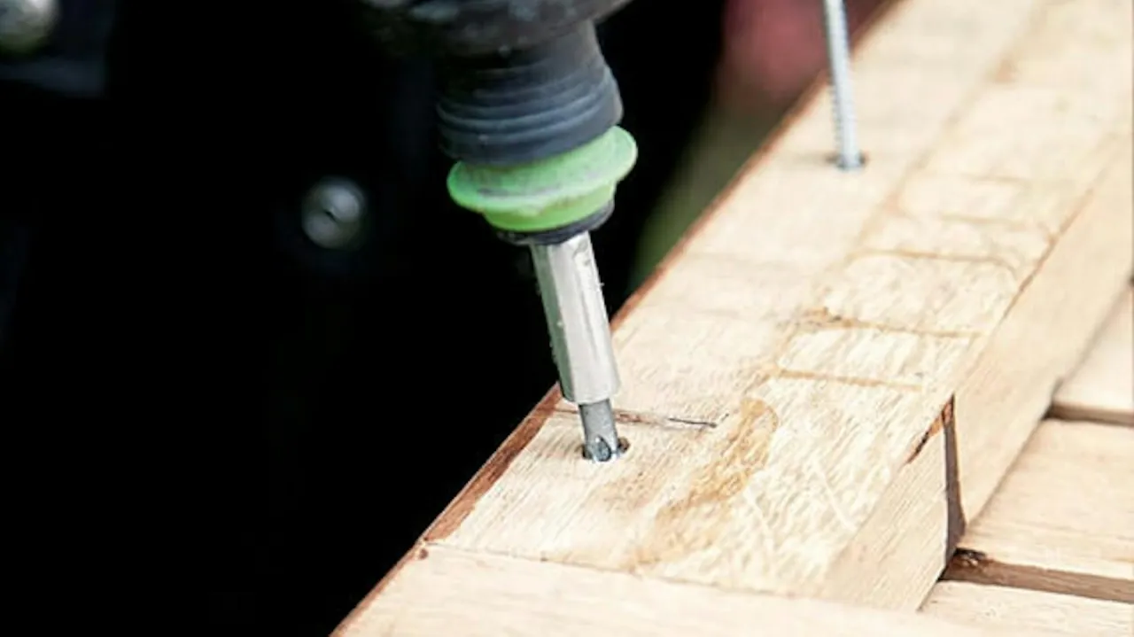 Wkręcanie śruby w drewno to kluczowy etap, jak zbudować ławkę ogrodową drewnianą. Precyzja i odpowiednie narzędzia zapewnią trwałość.