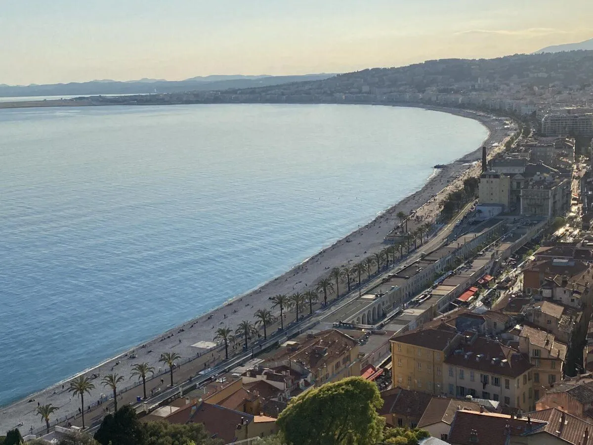 Widok na zatokę i plażę w Nicei. Idealne miejsce, by zobaczyć, co zwiedzić w Nicei, spacerując promenadą.