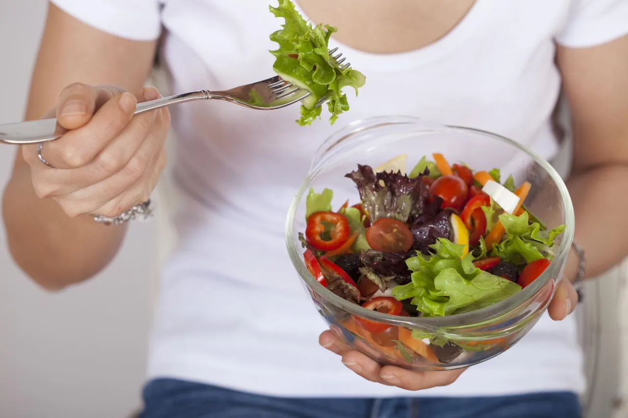 Kolorowa sałatka z pomidorów, papryki i sałaty, idealna na co dzień dieta roślinna. Widok z góry na miskę i widelec z porcją sałatki.