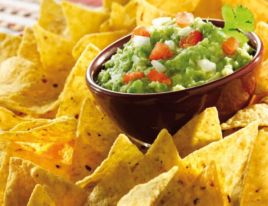 Plato de nachos apetitosos con guacamole y queso