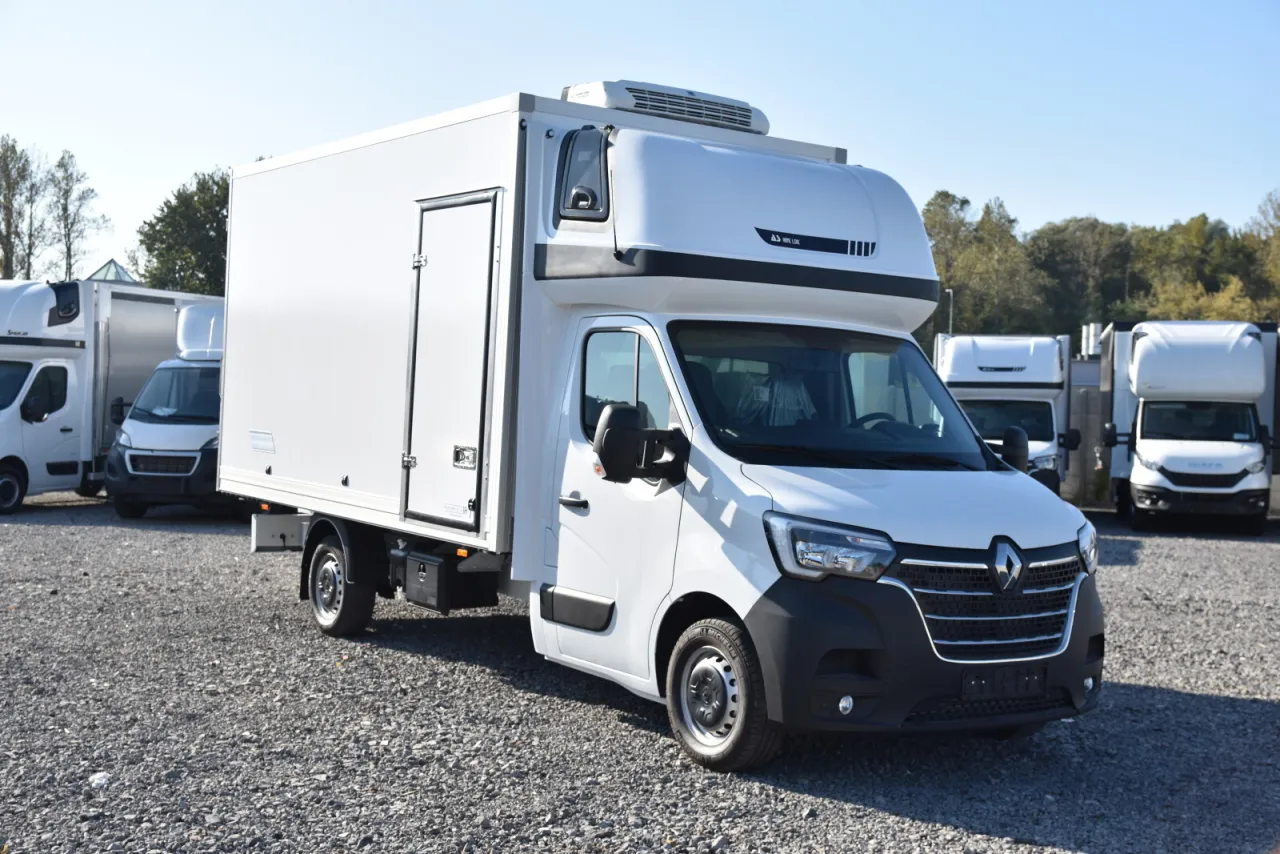 Biały bus na budowę, z chłodnią na dachu, gotowy do pracy. Idealny do transportu materiał&oacute;w.
