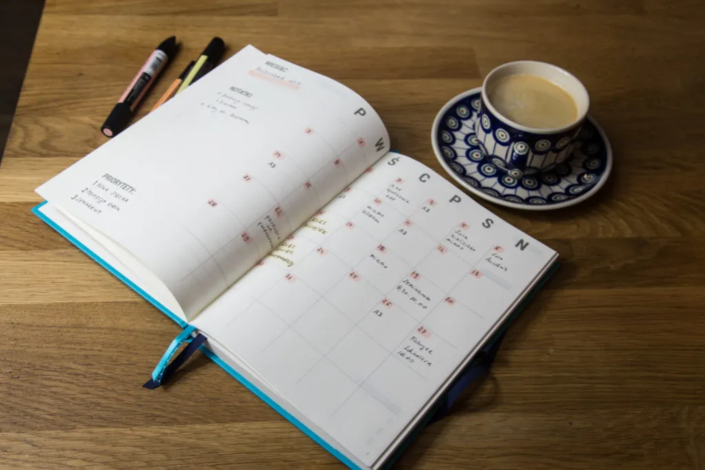 Osoba planująca naukę języka, z kalendarzem i notatkami