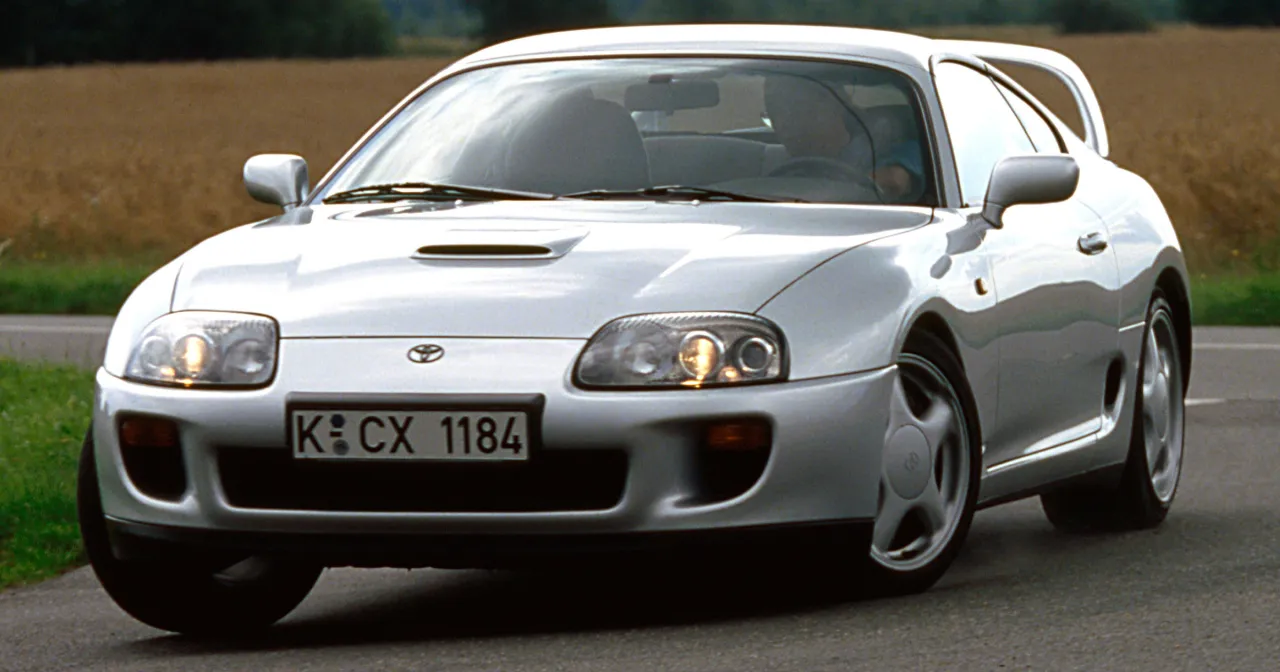 Srebrna Toyota Supra mk4 na drodze. Zastanawiasz się, toyota supra ile ma koni? Ten kultowy samoch&oacute;d potrafi zaskoczyć mocą.