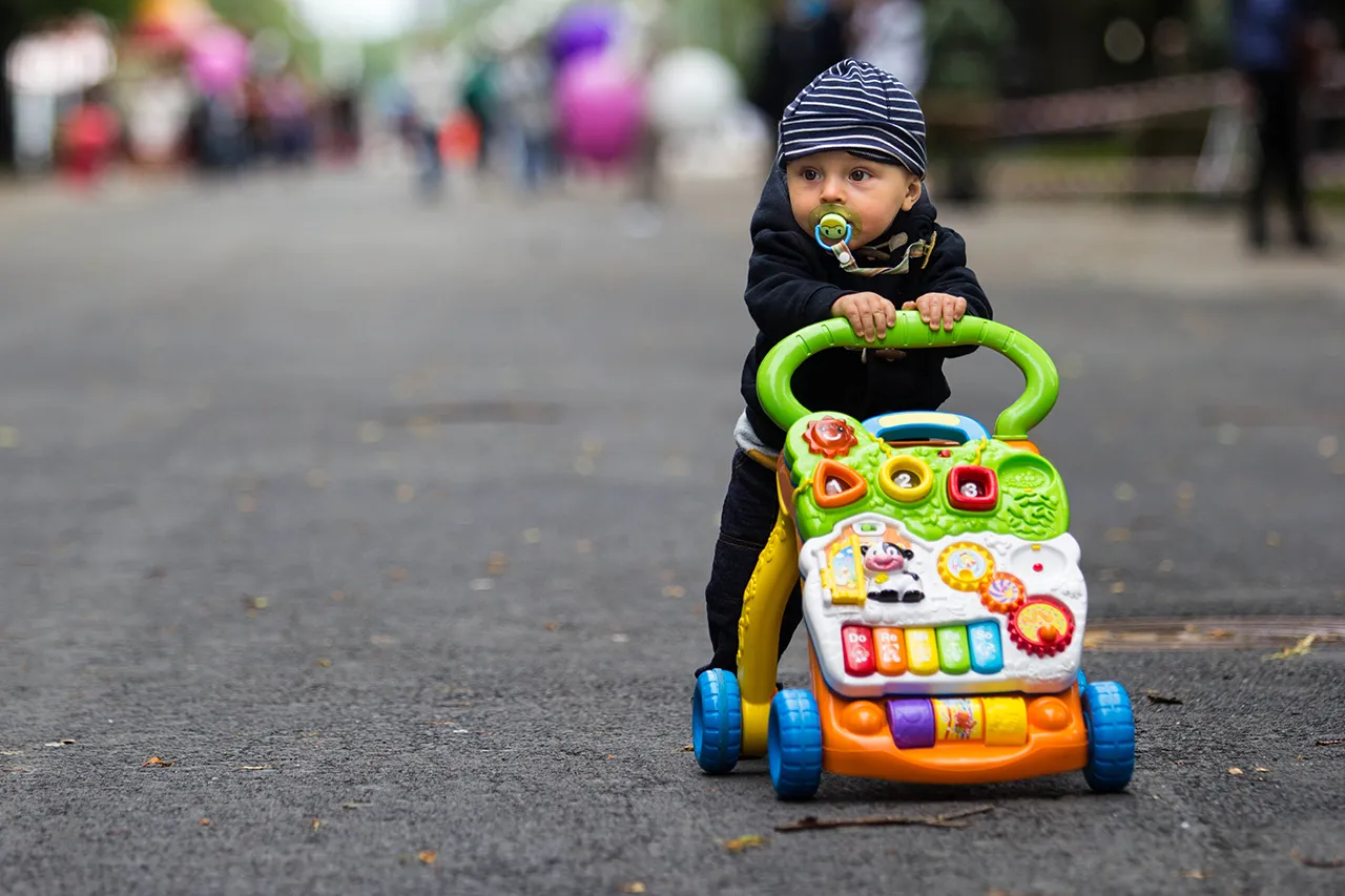 dziecko używające pchacza do nauki chodzenia