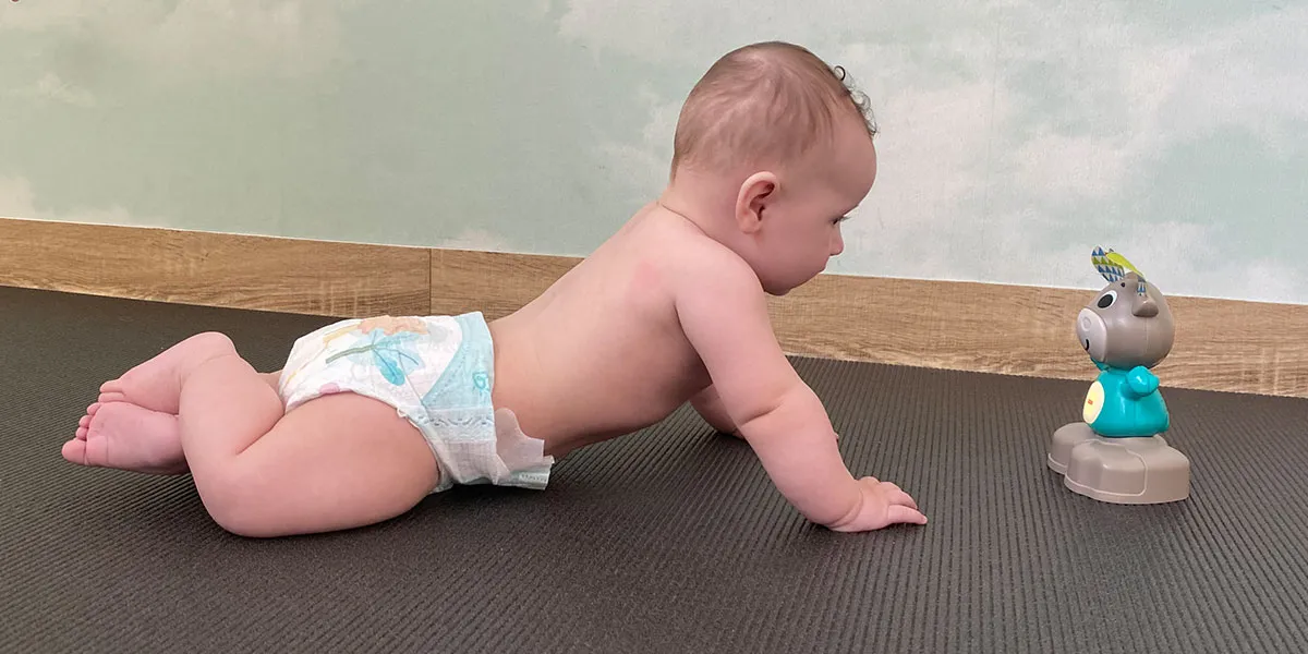 niemowlę leżące na brzuchu unosi głowę