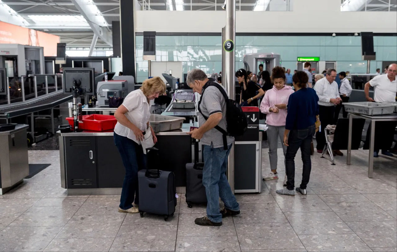 Po odprawie online, na lotnisku czekają kolejne kroki: kontrola bezpieczeństwa. Pasażerowie przygotowują bagaże do prześwietlenia.
